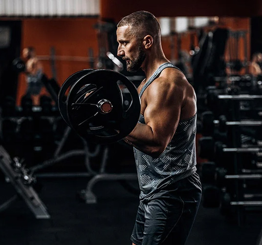 A male trainer curling weights