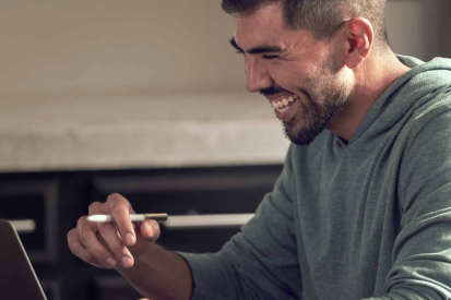 A man smiling at his tablet