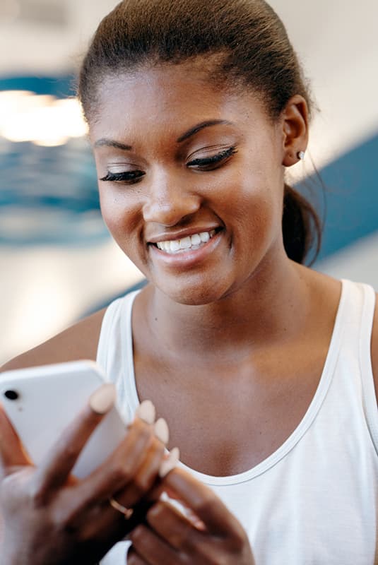 A woman smiling at her phone