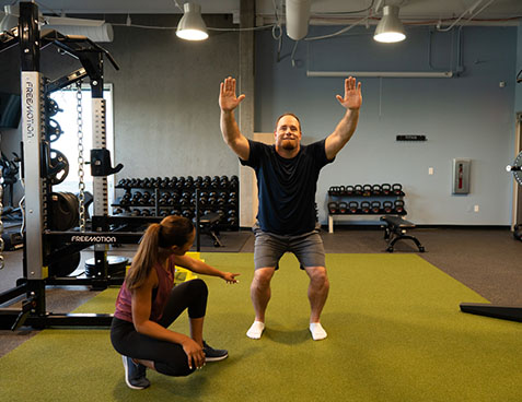 client doing overhead squat assessment