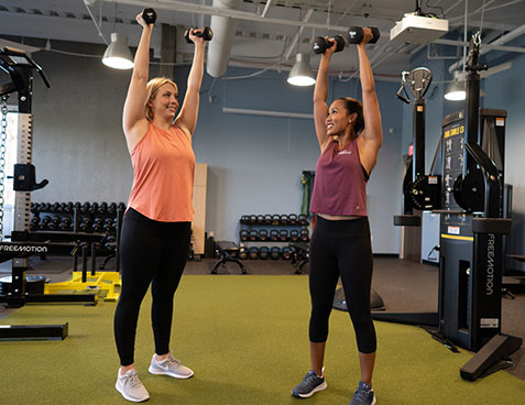 personal trainer and client holding dumbbells